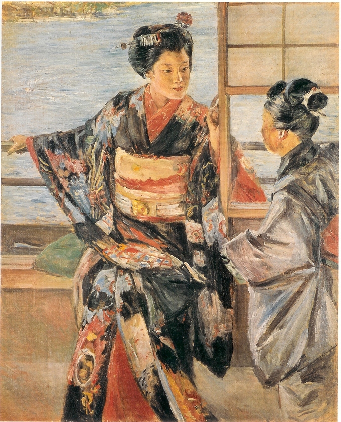 Two women in traditional garb sit and talk.