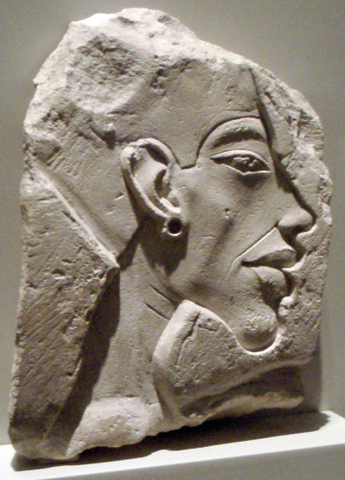 Relief portrays a profile view of Akhenaten's face. He has a prominent chin and wears an earring and pharaoh's head piece.