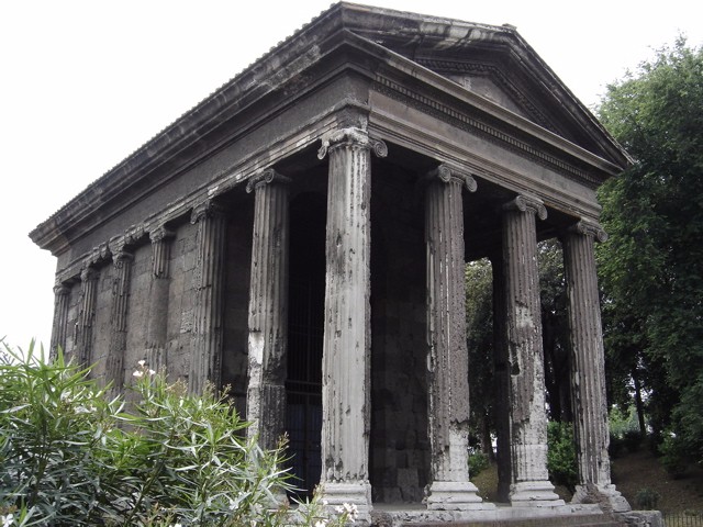 Photograph of the temple, a rectangular structure. The front is four columns wide and two columns deep.
