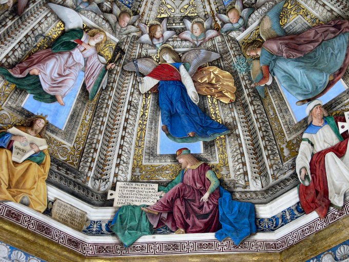 Fresco depicting angels in colorful robes who appear to be extended in space, floating.