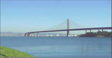 Color photograph of Oakland Bay bridge taken from the shore of the bay.