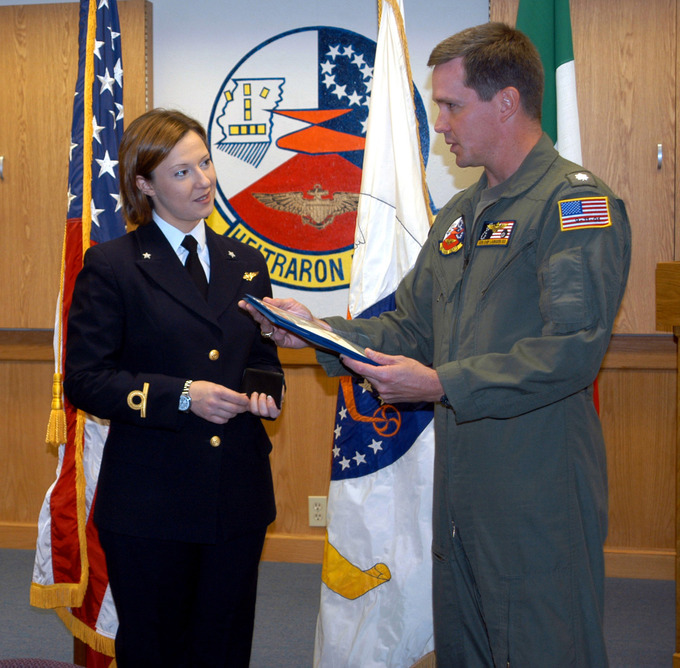 Midshipman Daniela Giordano makes eye contact while receiving her her winging certificate from Commander Chip Laingen.