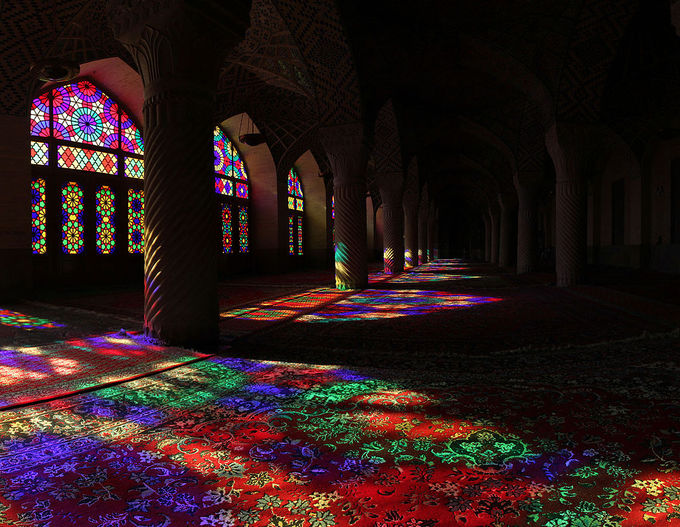 The sun shines through stained glass windows at the Nasir ol Molk Mosque located in Shiraz, Iran.
