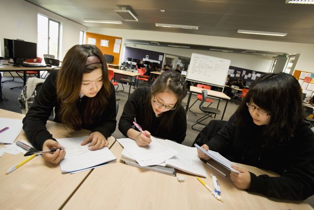 A picture of three students studying.