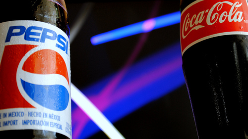 A photograph of a Pepsi bottle and a Coke bottle