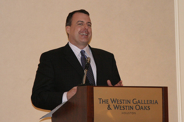 A picture of Bryant A. Hilton, a public relations representative for Dell, giving a speech entitled 