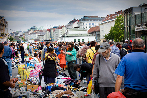 an open market in Vienna with many people crowding the streets.