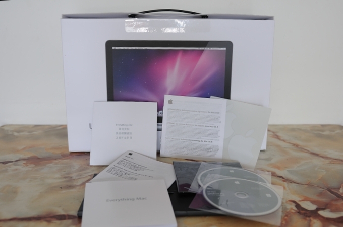A photo of the pamphlets and CDs that come with an Apple product as part of the warranty.