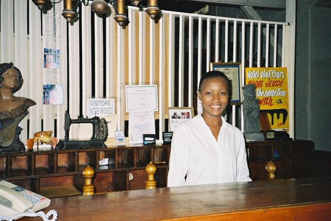 A hotel clerk stands behind the front desk.