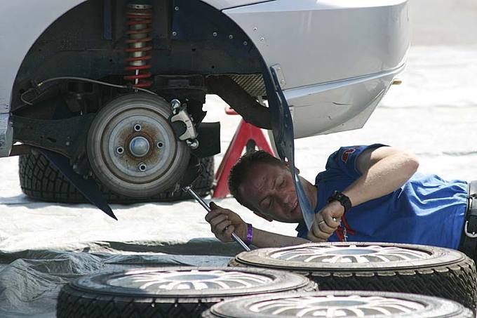 A man fixing a car from underneath