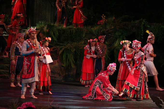 Cultural performers take part in a show on a large stage.