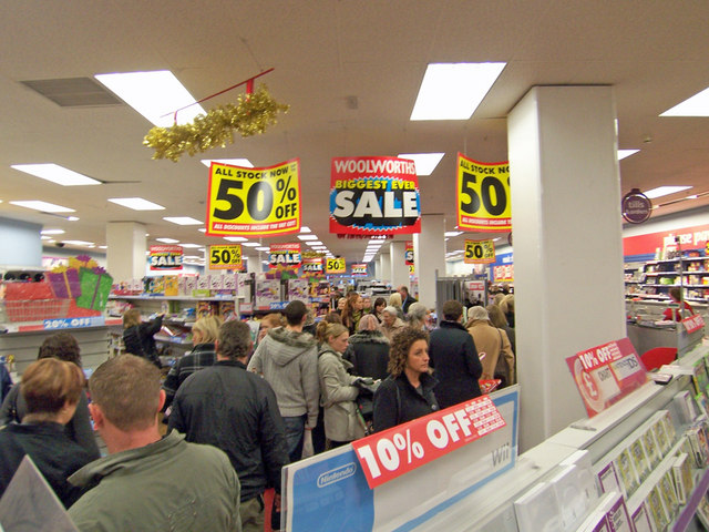 Customers shop in a store that has lots of different sale signs.