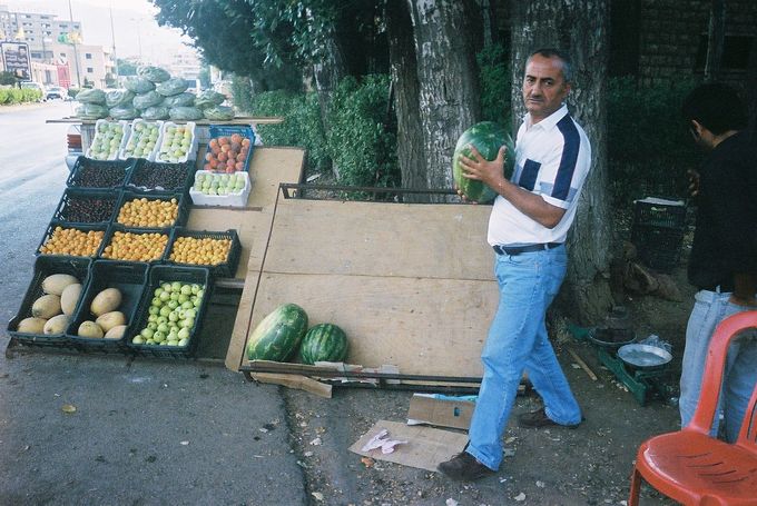 A man buys a watermelon at a fruit stand in Lebanon.