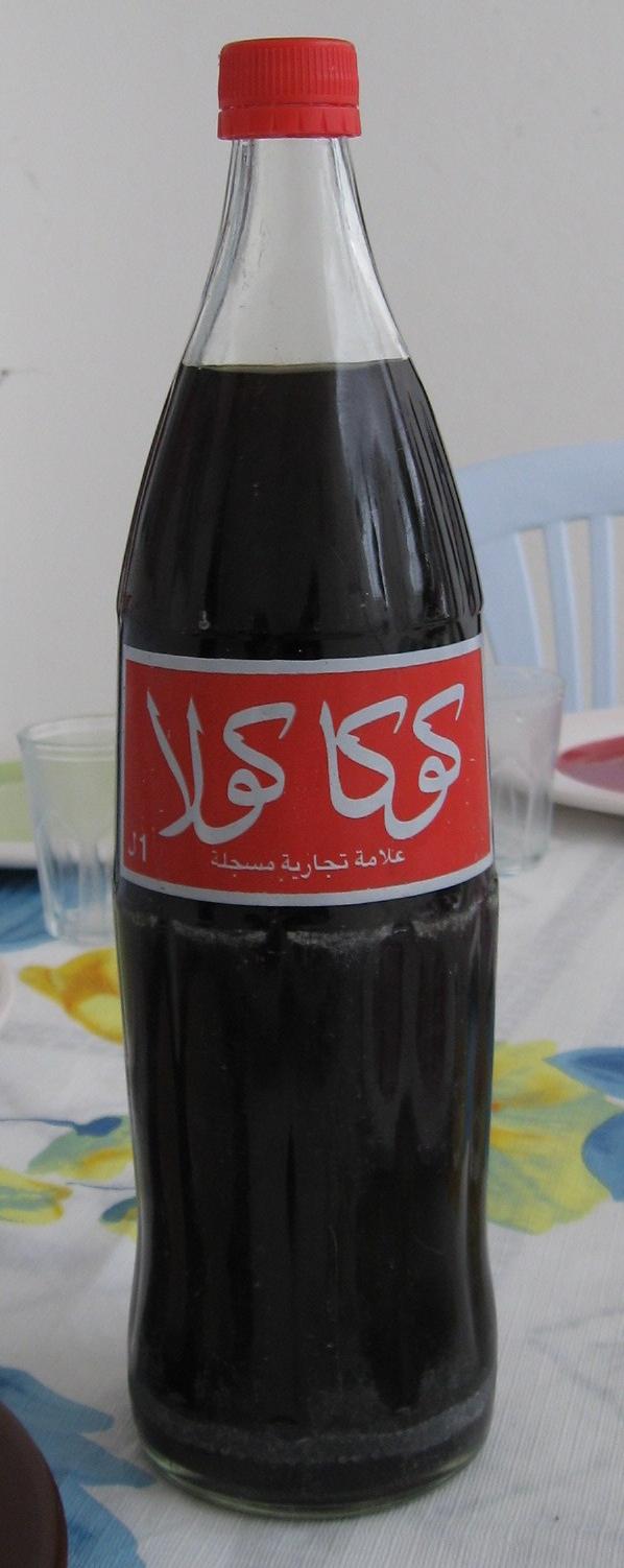 A Coca-Cola bottle with the label in Arabic.