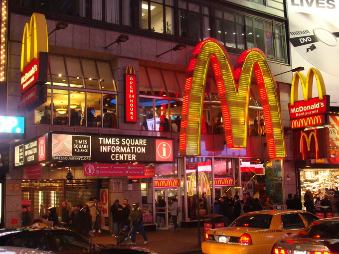 A large McDonalds with light-up signs around it in a city center