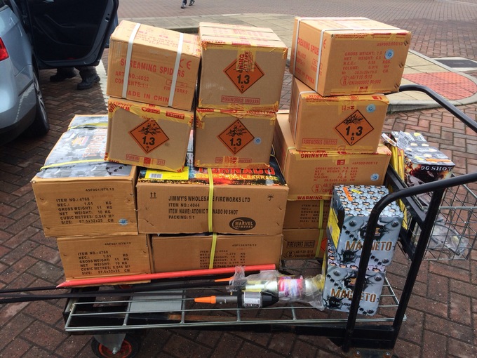 A cart that's loaded with large boxes of fireworks.