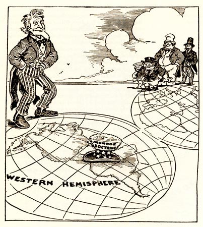 The cartoon shows Uncle Sam standing on a map of the Western Hemisphere. His top hat, ornamented with stars, stripes, and the label 