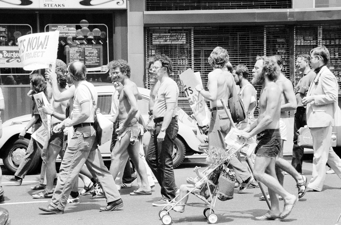 A group of white men, some holding signs, marching down a NYC street.