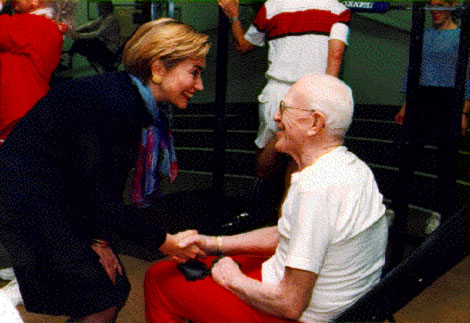 First Lady Hillary Clinton shaking hands with an elderly man