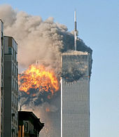 The image shows the twin towers of World Trade Center engulfed in flames and smoke.