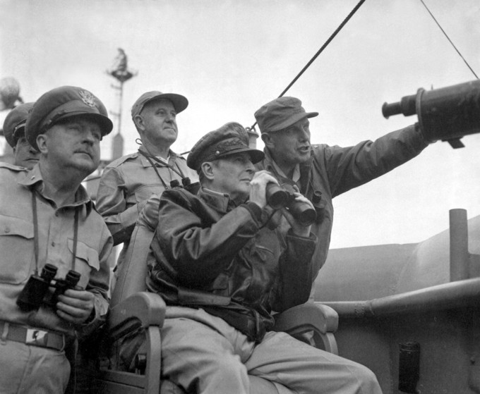 Photograph of Brigadier General Courtney Whitney, government section, Far East Command; General Douglas MacArthur, Commander-in-Chief, United Nations Command, and Major General Edward Almond, Commanding General, X Corps in Korea, observing the shelling of Incheon from the USS Mount McKinley.