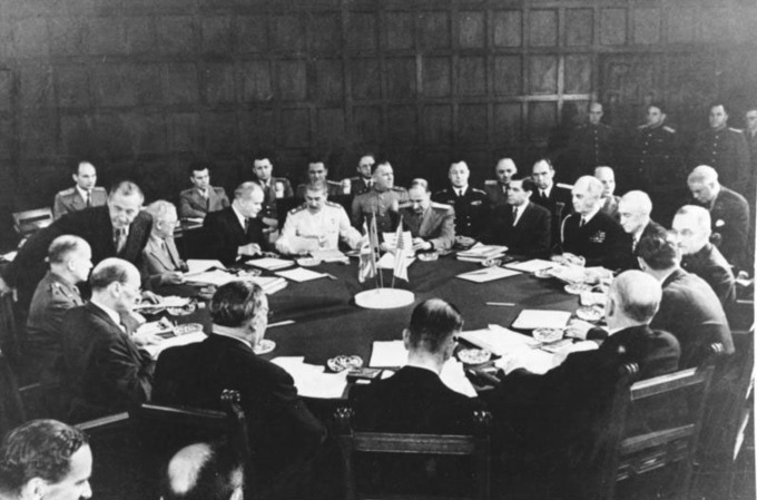The photograph shows the leaders of the major Allied powers seated at a round table.
