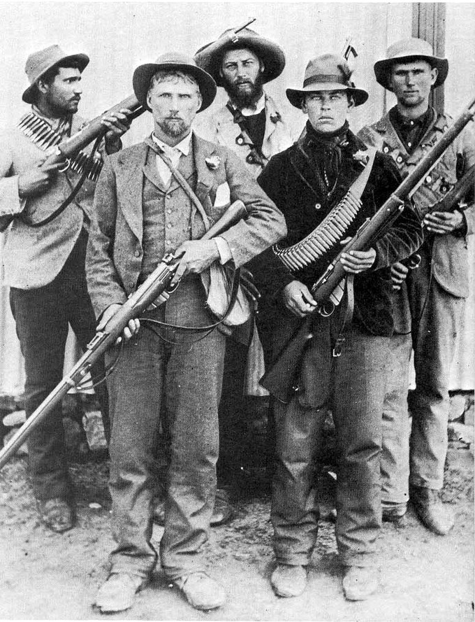 Photo of Boer soldiers, dressed in civilian clothes, armed with rifles and ammunition.