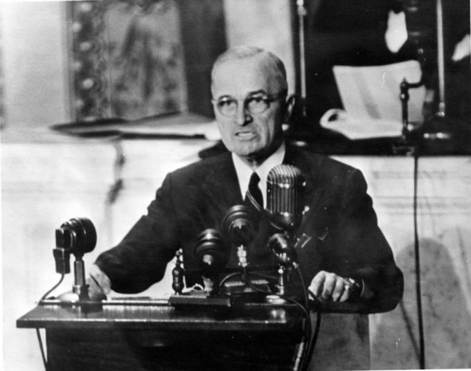 A photo of President Truman in front of several microphones giving a speech.