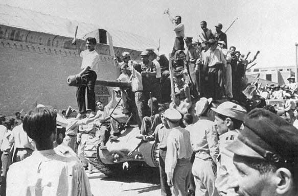 Photo of a tank covered by men celebrating the Coup in the streets of Tehran, 1953