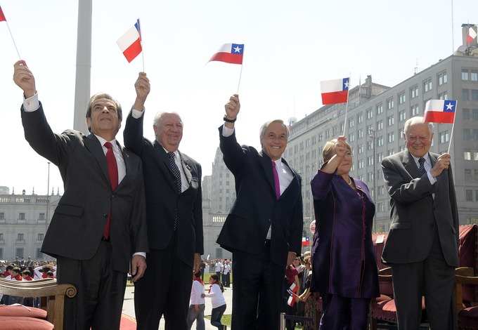 Photo of the five most recent presidents on Chile standing side by side, waving Chilean flags.