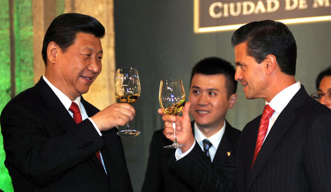 Photo of President Enrique Peña Nieto with President of China Xi Jinping, standing, looking at each other with smiles, toasting with a glass of white wine.