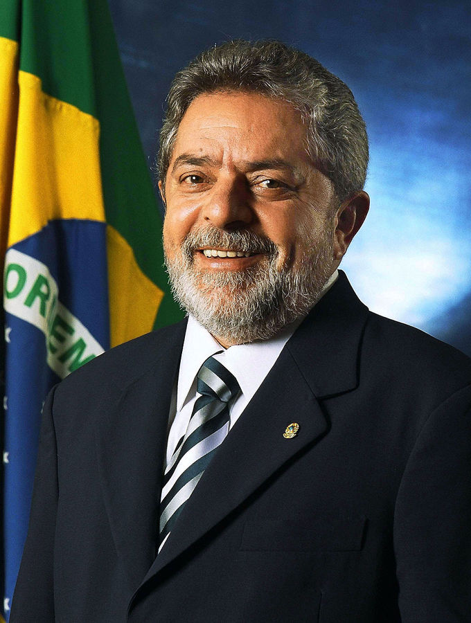 Close-up photo of President Luíz Inácio Lula da Silva in front of a Brazilian flag.
