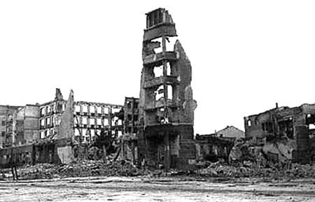 Photo of the ruined city of Stalingrad after WWII. Many buildings are collapsed entirely, while some have a few walls remaining.