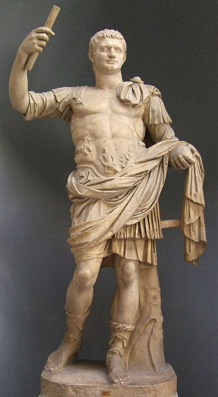 An image of a full-body statue of Domitian holding up his right hand with a scroll.