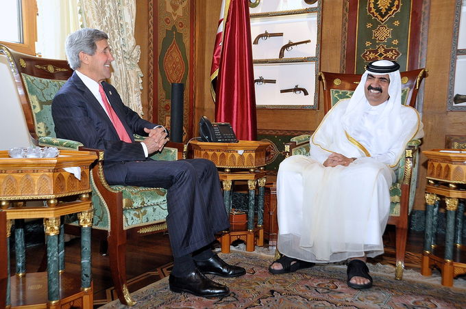 Photo of former Emir Hamad bin Khalifa Al Thani and US Secretary of State John Kerry in 2013, seated, talking with one another in a ornately decorated room.