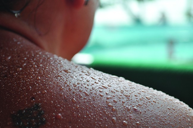 A photograph of a person's back beaded in sweat is shown.