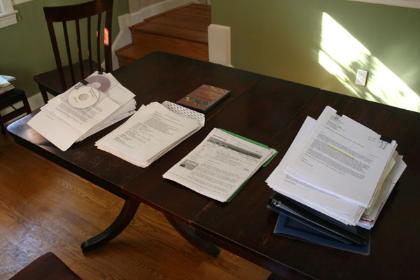 Several stacks of cover letters on a table.