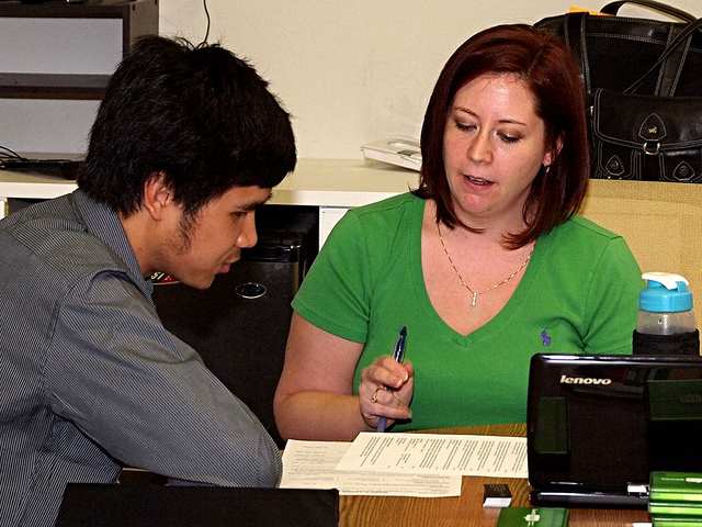 A counselor going over a résumé with a student.