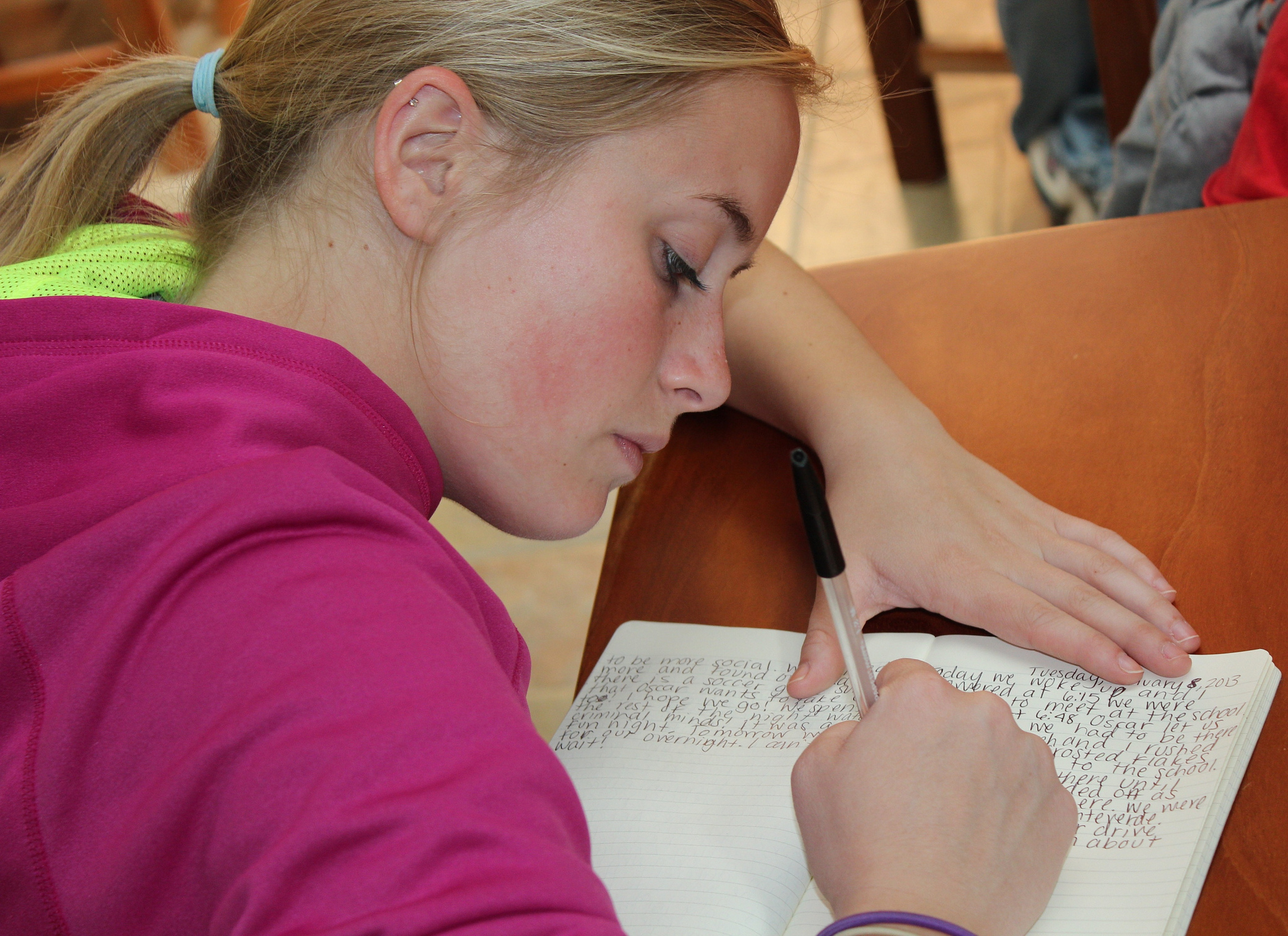 Photo of a young woman writing in a notebook