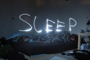 Sleep written in light above sleeping person