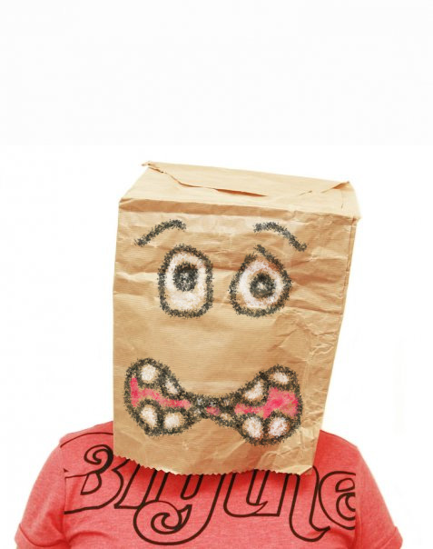 Person wearing paper bag on head with worried expression drawn on