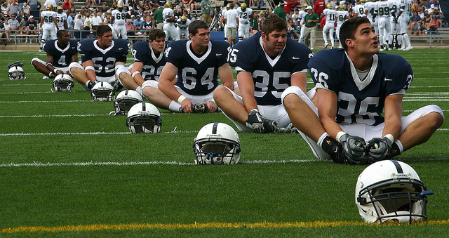 Football players stretching on field