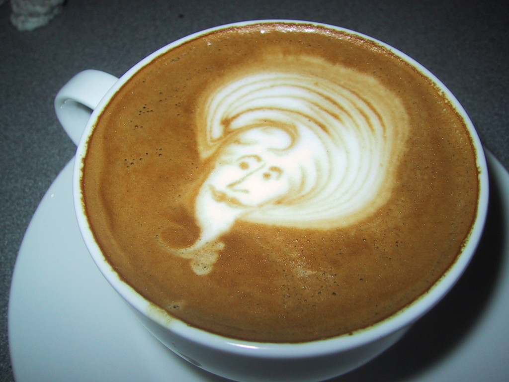 Photo of a cappuccino with a genie picture artfully drawn in the foam. An example of coffee 