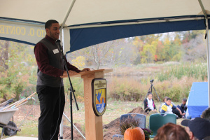 A person giving a speech to a group of people outdoors.