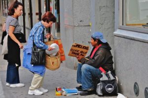 Woman helping homeless man on the street