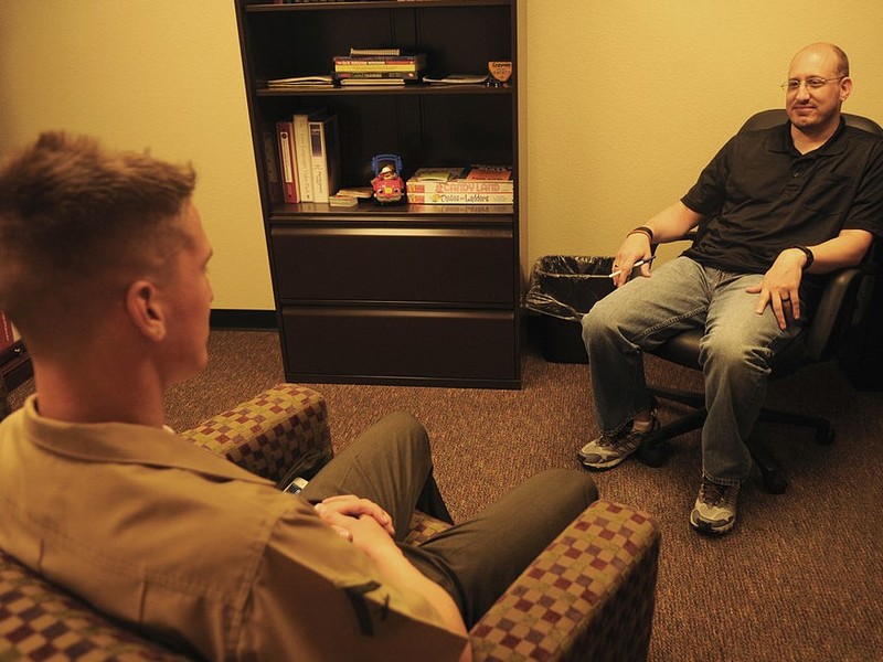 A therapist and patient sit facing one another during a session.