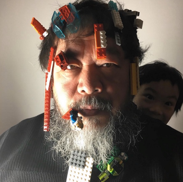 A man with lego blocks stuck to his hair and beard.