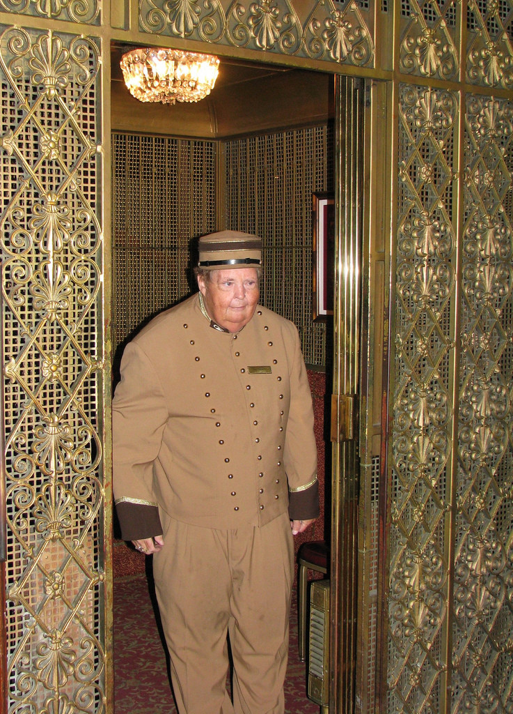 An elevator operator standing in an elevator
