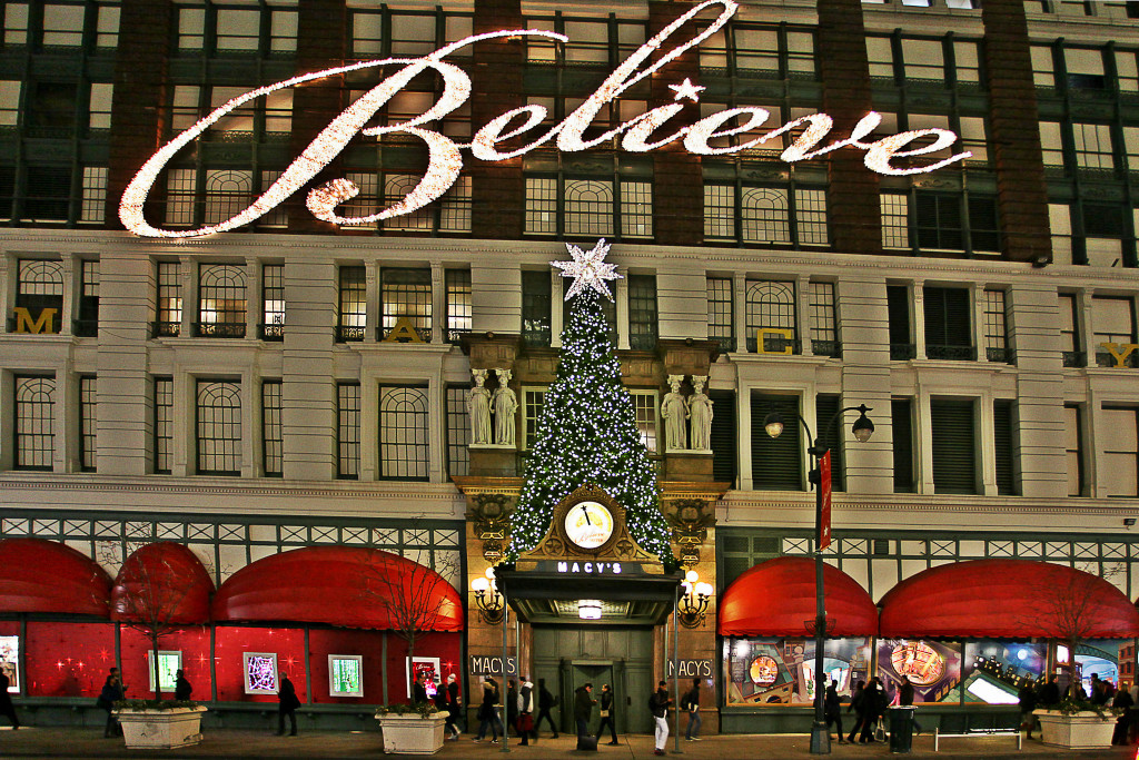 Front view of Macy's department store in New York City, decorated at Christmastime with a large white lighted sign spelling the word BELIEVE.