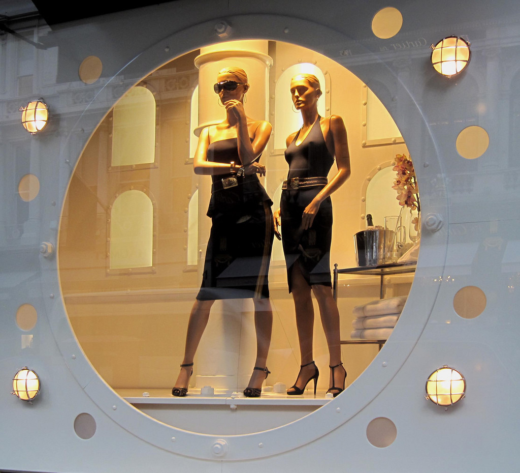 Photo of two female manikins wearing black dresses in a Ralph Lauren display window.